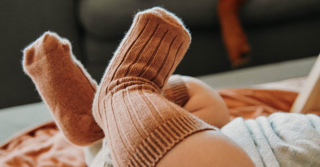 Bébé avec chaussettes légères en coton tricoté